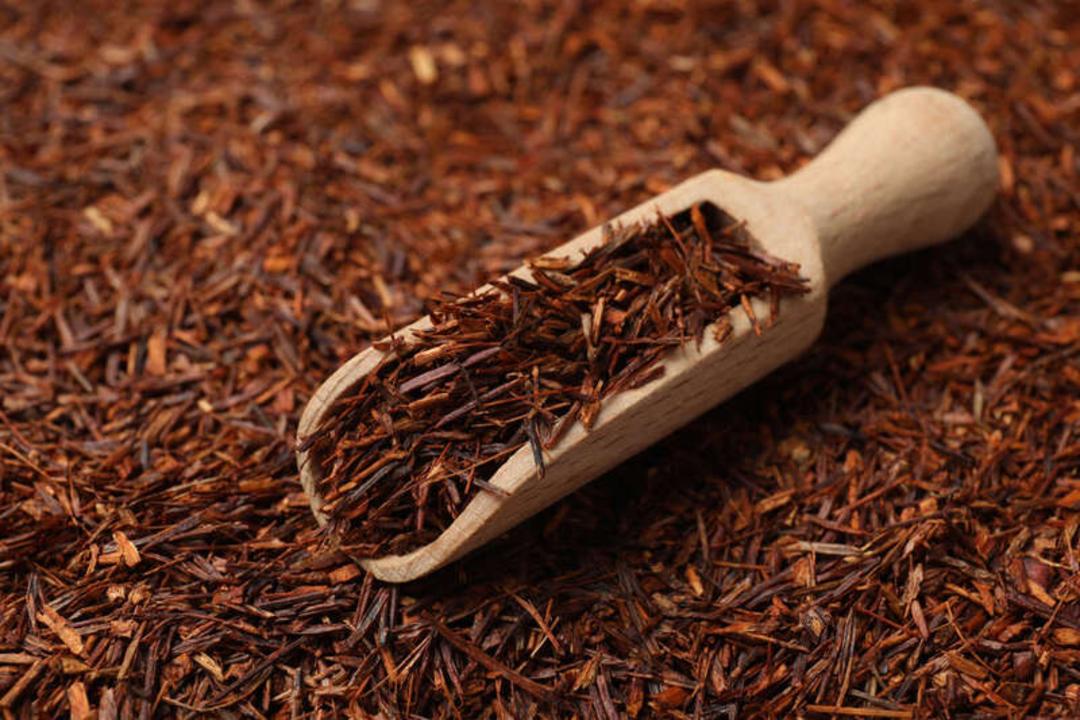 برگ‌های خشک چای سیاه در یک پیمانه چوبی کوچک