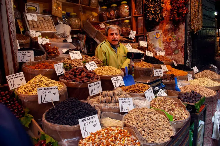 انواع میوه خشک و آجیل در بشکه‌ها و ظرف‌های چوبی در مغازه