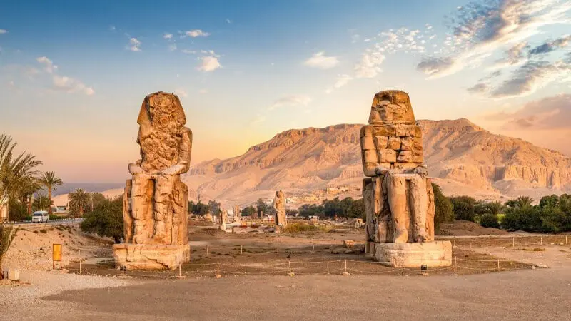 مجسمه‌ های غول‌ آسای ممنون با پس زمینه کوه ها