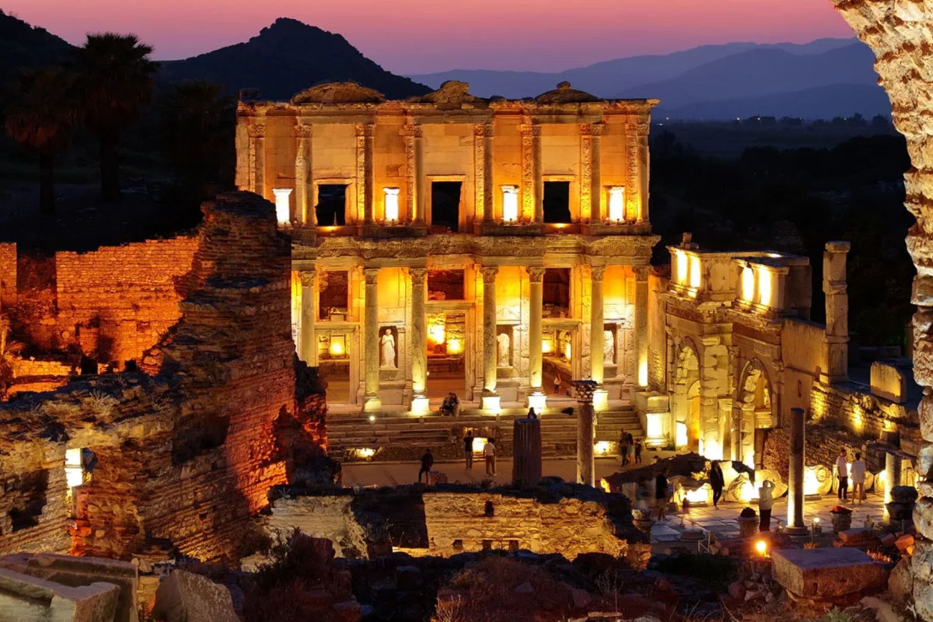 نمای شبانه و نورپردازی شده کتابخانه سلسوس در قاب طاق‌های سنگی باستانی افسوس