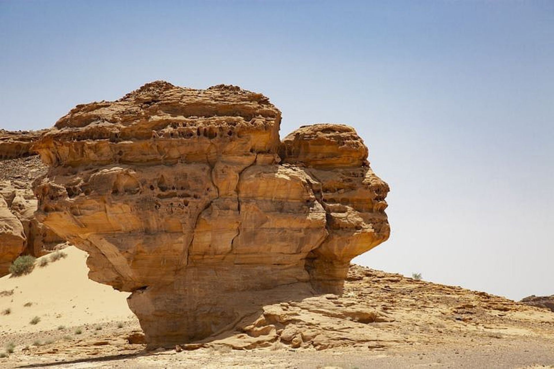 سنگی به شکل سر انسان در میان بیابانی در عربستان