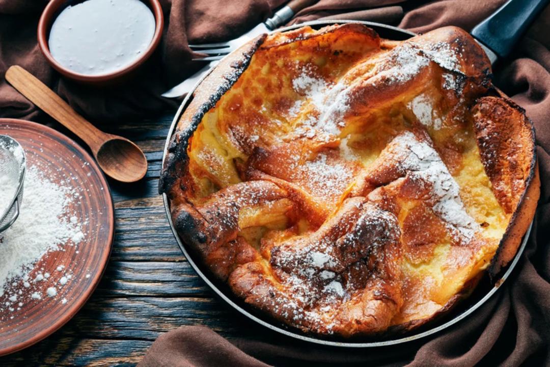 پنکیک کرپ فرانسوی (Dutch Baby Pancake) پاشیده شده با پودر قند در تابه