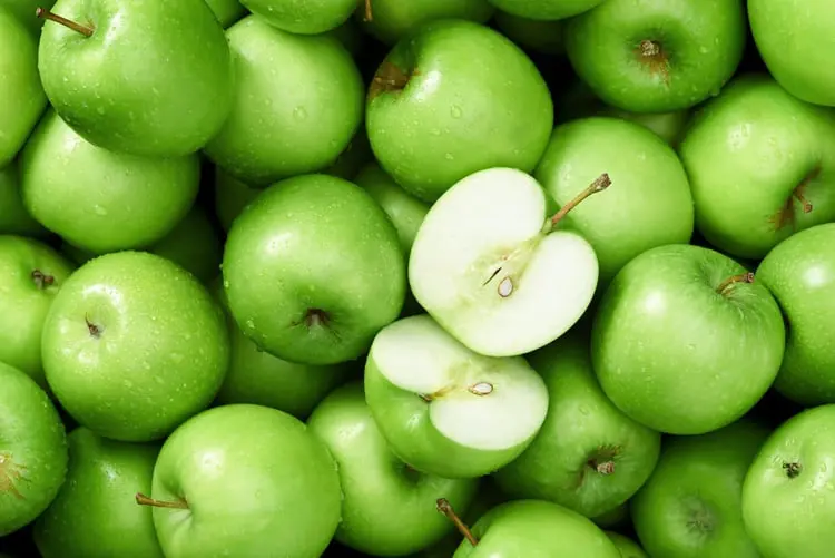سیب‌های سبز (Green Apples) تازه با قطعه‌ای برش خورده در مرکز