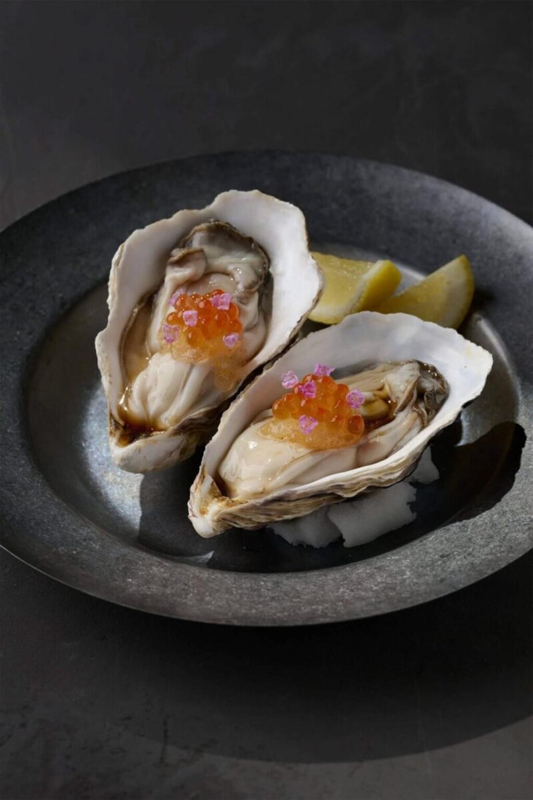 صدف خام (Oyster) چیده شده در صدف همراه با تخم ماهی نارنجی و تکه‌های لیمو