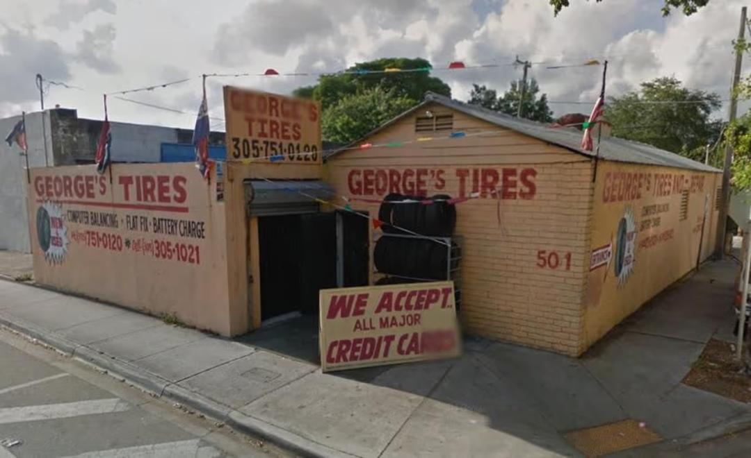 نمای بیرونی مغازه لاستیک‌فروشی جورج (George's Tires) با تابلوهای تبلیغاتی
