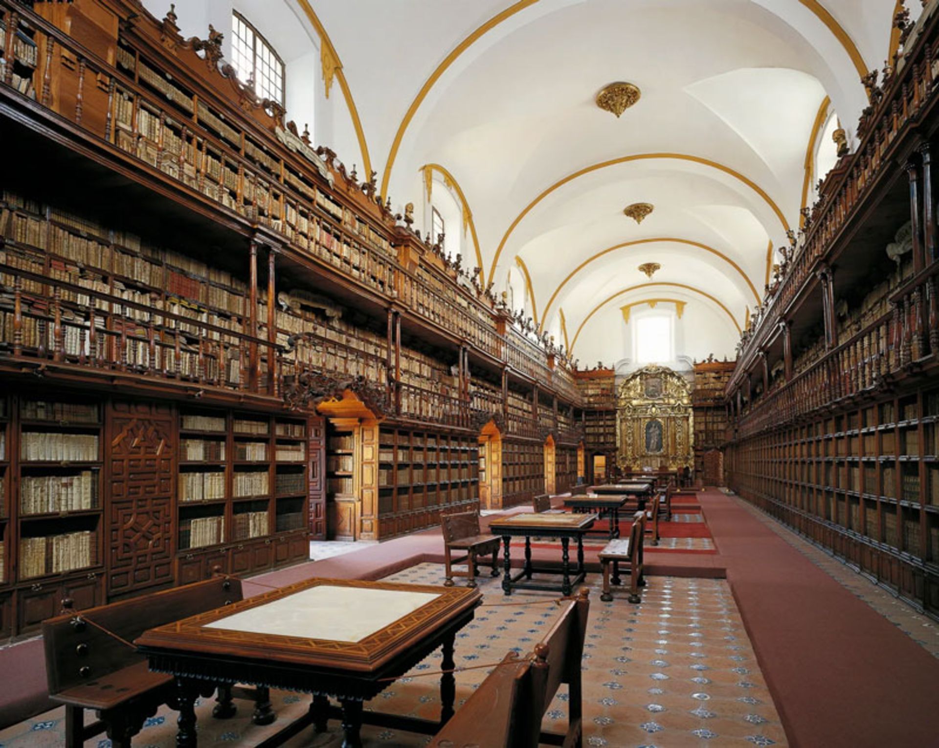 نمای بلند سالن کتابخانه پالافوکسیانا در پوئبلا مکزیک با قفسه‌های چوبی سه طبقه.