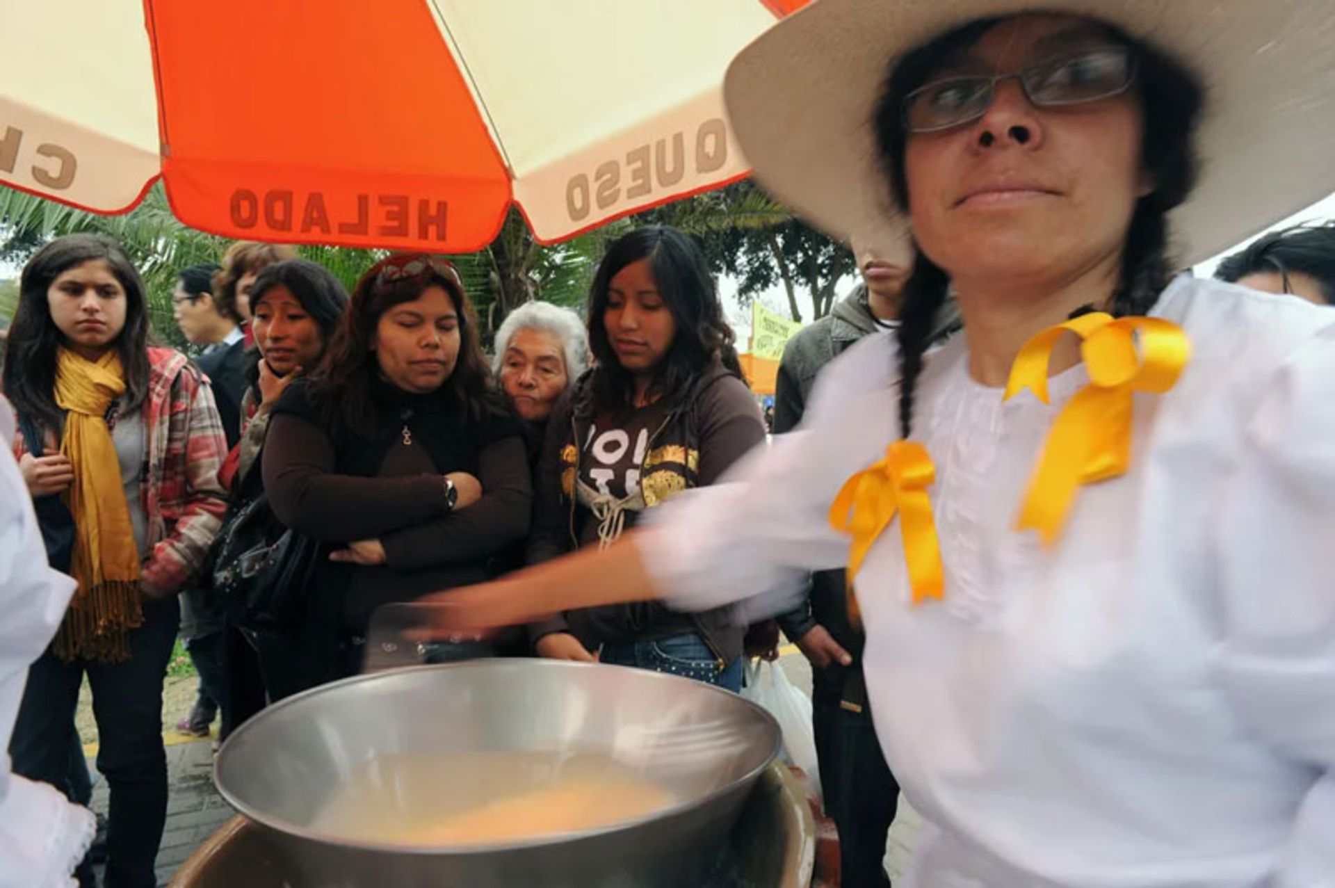 زنان پرویی با لباس سنتی در حال تهیه دسر پنیر یخ‌زده