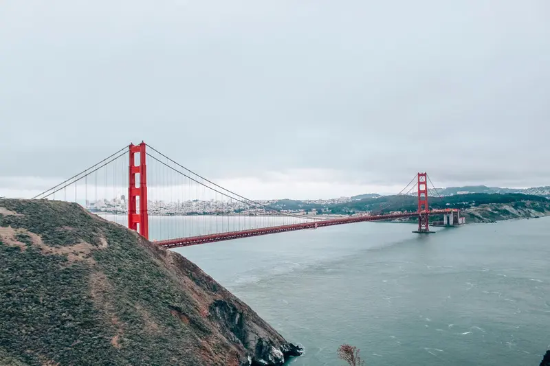 پل گلدن گیت (Golden Gate Bridge) با سازه قرمز رنگ در میان مه و دریا