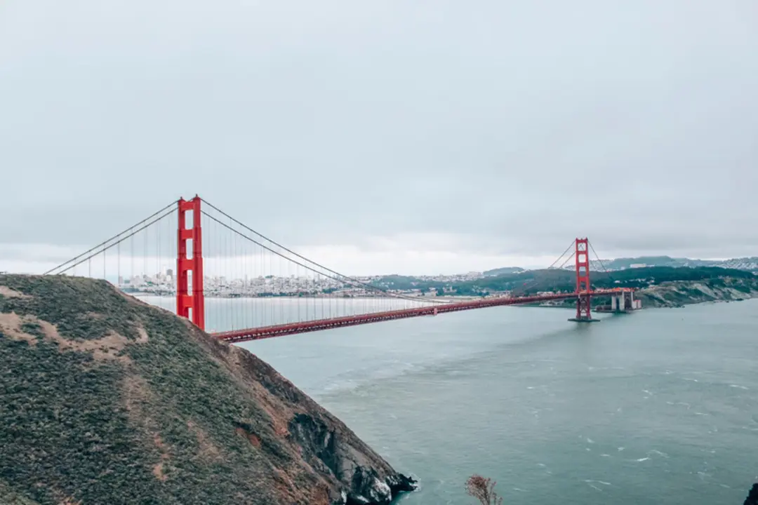 پل گلدن گیت (Golden Gate Bridge) با سازه قرمز رنگ در میان مه و دریا