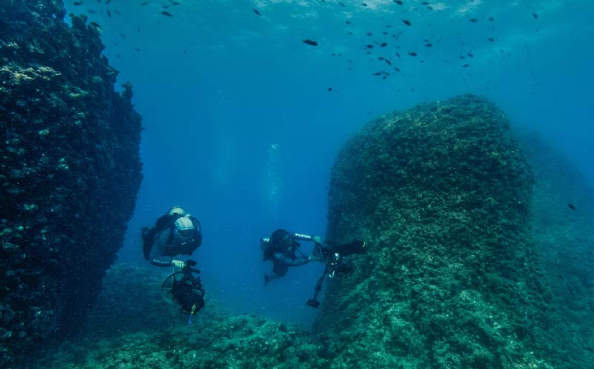 دو باستان‌شناس در حال تصویربرداری و بررسی صخره‌ها و بقایای باستانی در زیر آب