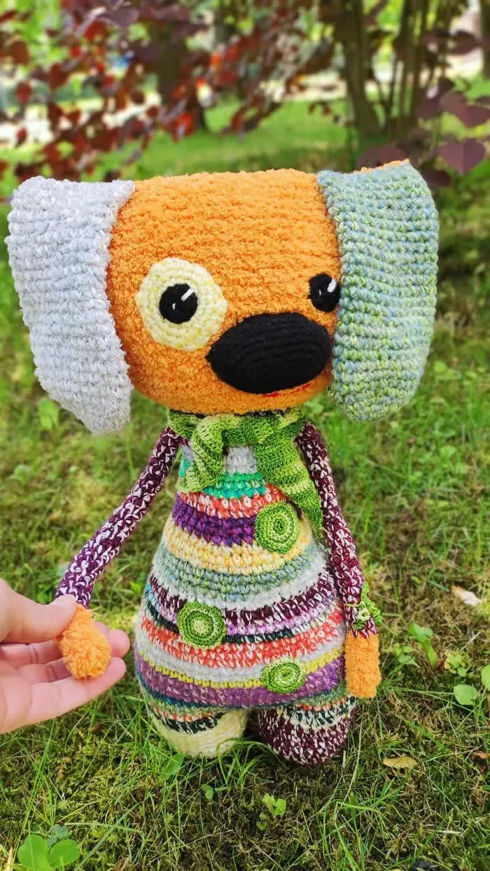 عروسک قلاب‌بافی (Crochet) با بدن رنگارنگ و گوش‌های بزرگ سفید و آبی
