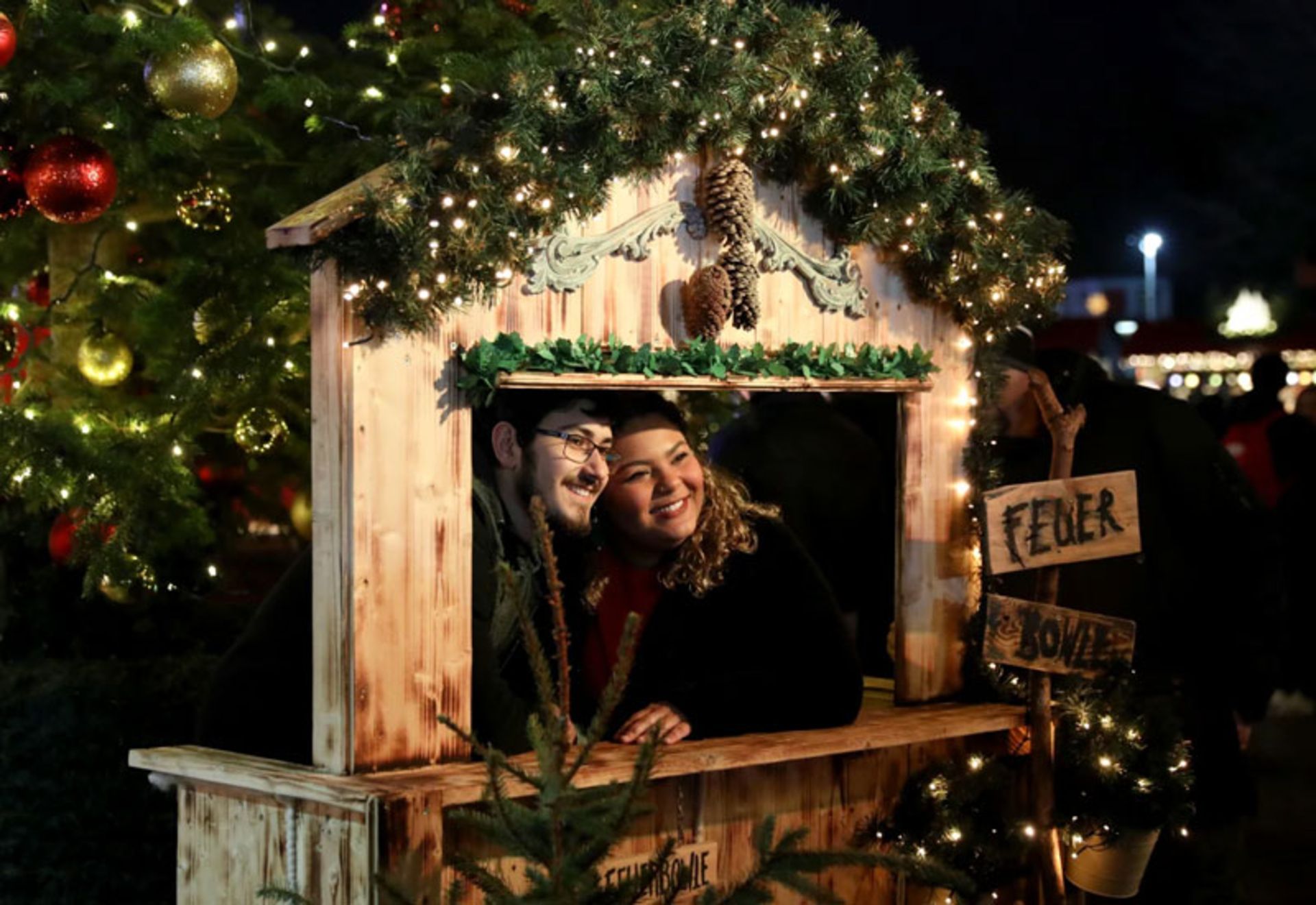 زن و مردی در حال عکس گرفتن در بازار کریسمس هاید پارک لندن