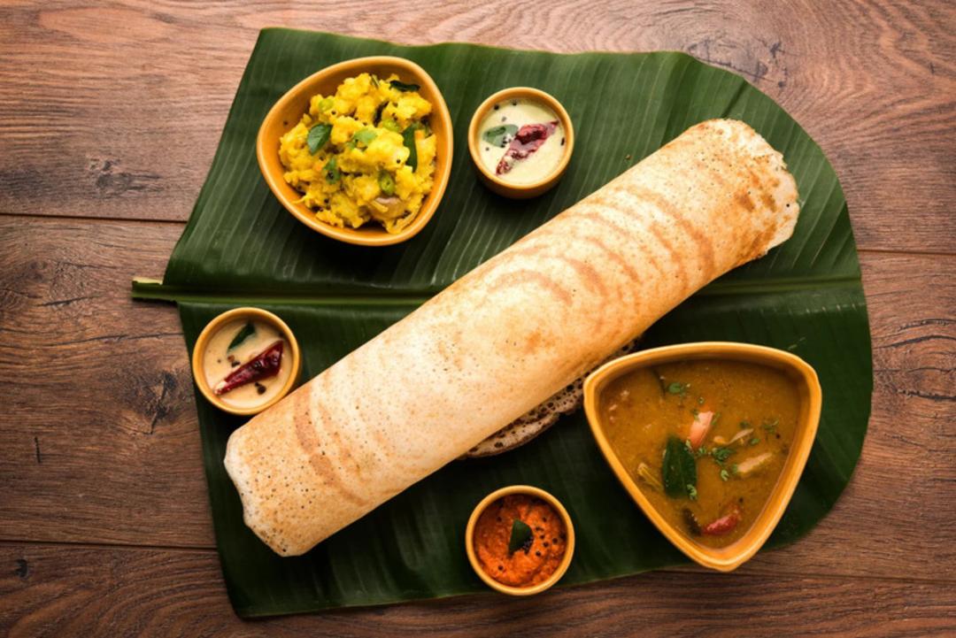 پنکیک دوسای (Dosa) هندی روی برگ موز همراه با انواع چاشنی و خوراک