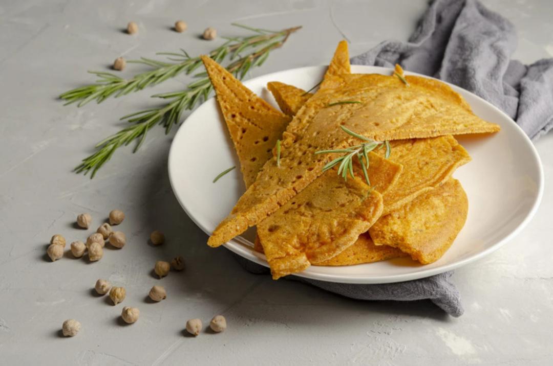 پنکیک دوسای (Dosai) هندی در یک بشقاب سفید همراه با گیاه رزماری