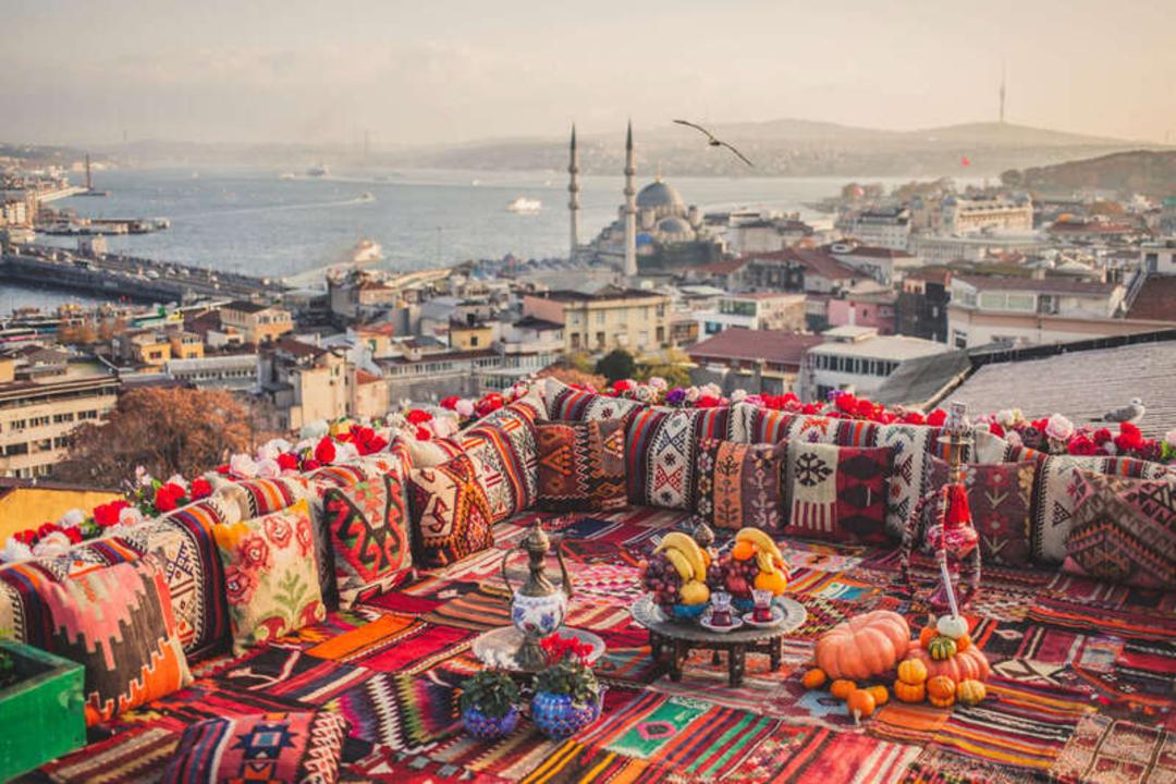 چای و خوراکی‌های سنتی روی یک چادر با پس‌زمینه شهر استانبول (Istanbul)