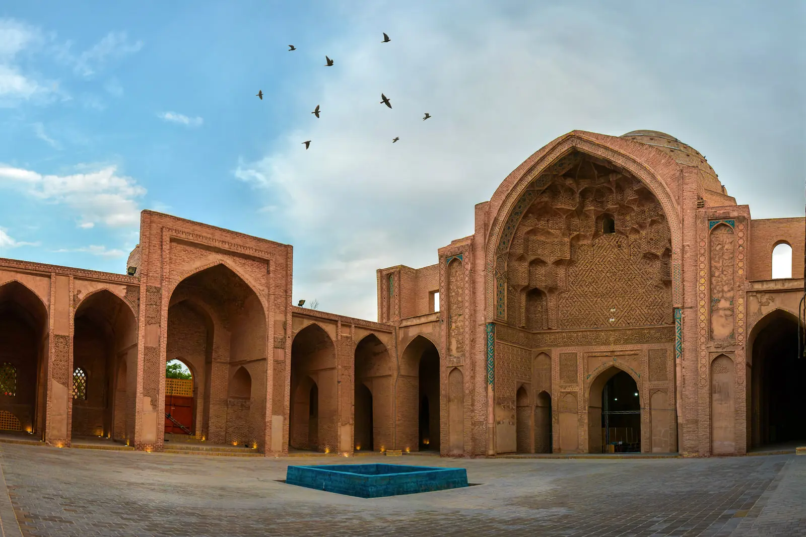 صحن آجری مسجد جامع ورامین با ایوان بزرگ و گنبد آجری