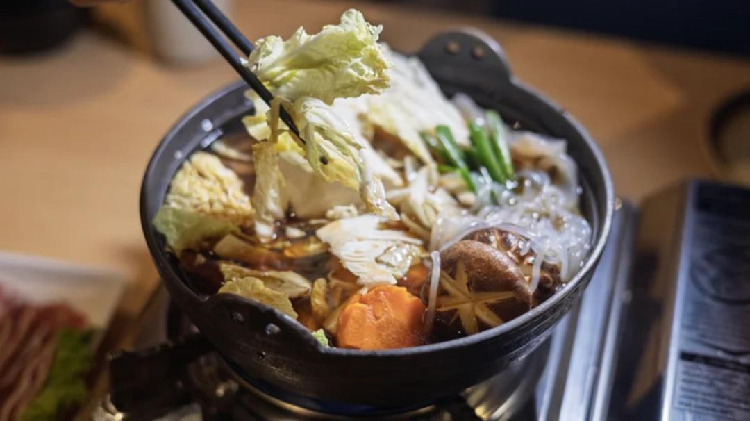 هات پات (Hot Pot) ژاپنی شامل کلم، قارچ و سبزیجات در قاب پاتلی سیاه