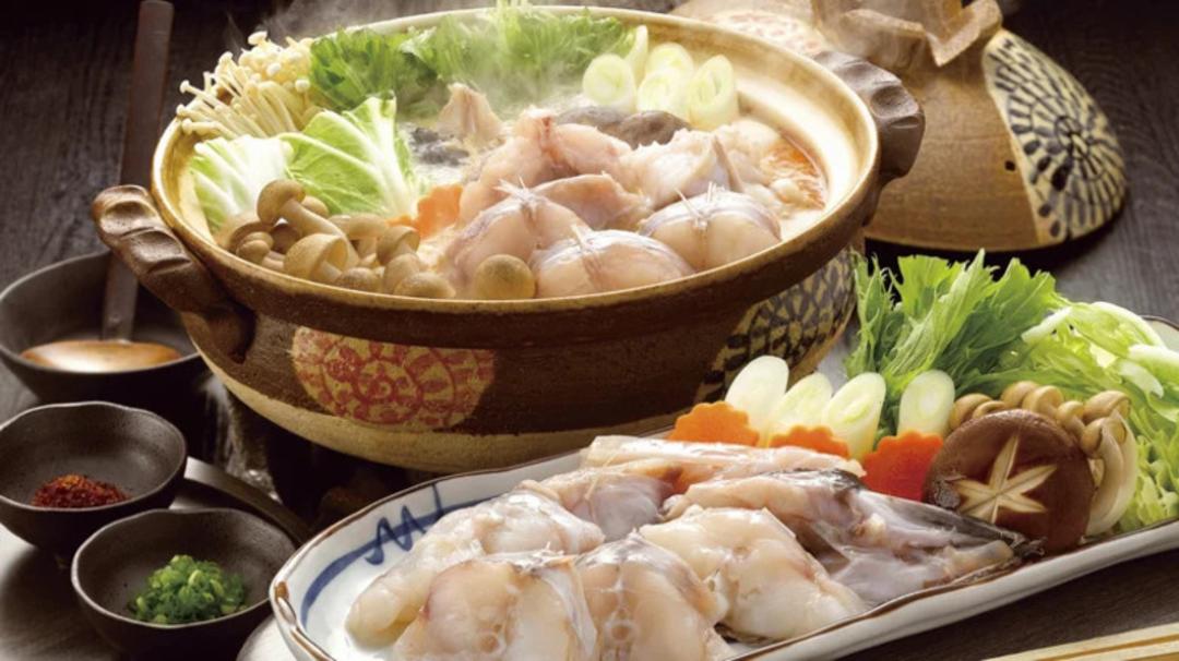هات پات (Hot Pot) ژاپنی شامل تکه‌های ماهی، قارچ و سبزیجات تازه در ظرف سفالی