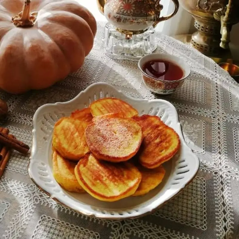شیرینی کاکا (Kaka) گیلانی در ظرف سفید روی میز با کدو تنبل