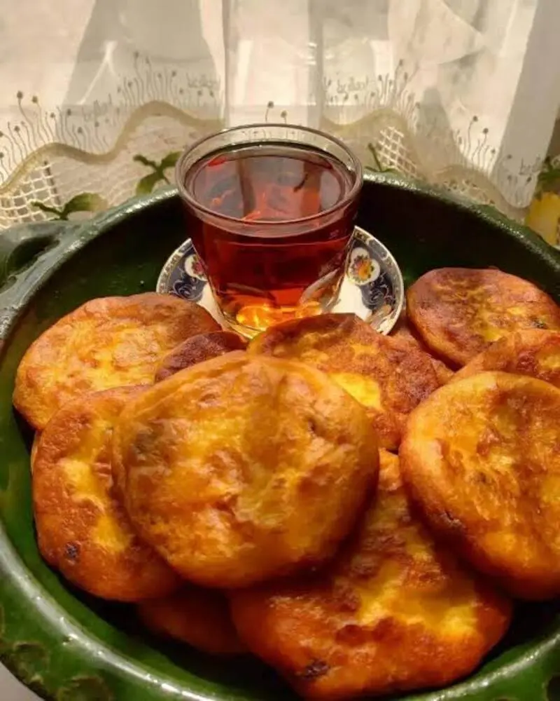 شیرینی کاکا (Kaka) گیلانی در کنار یک فنجان چای کمرنگ