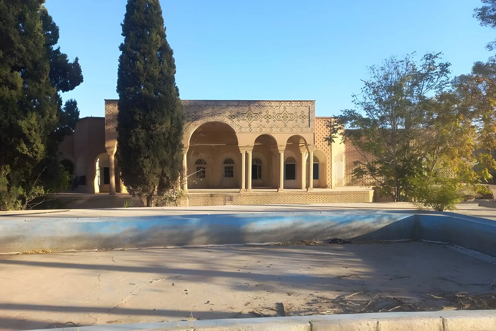 ساختمان تاریخی و قدیمی شرکت فرش کرمان با معماری سنتی و حوض آب