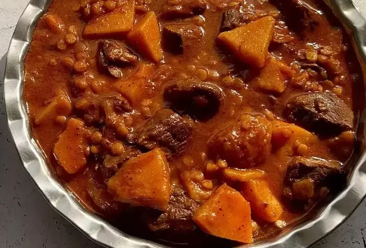 خورش به آلو شامل تکه‌های گوشت، آلو و عدس در سس غلیظ
