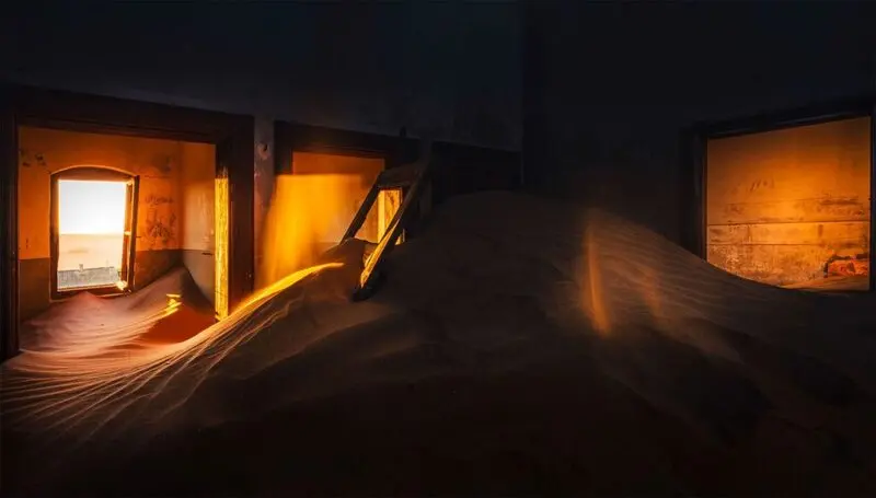 شن‌های روان در فضای داخلی یک خانه متروکه در شهر کولمانسکوپ (Kolmanskop)