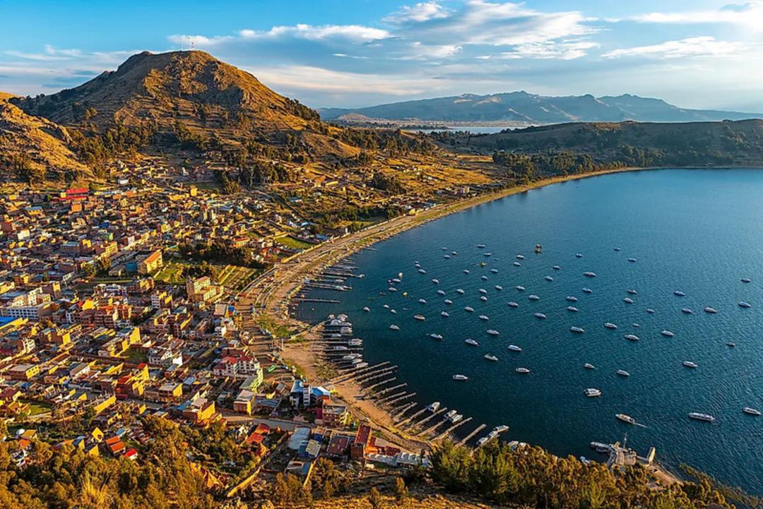 دریاچه تیتیکاکا (Lake Titicaca) در کنار شهر ساحلی در میان کوه‌ها
