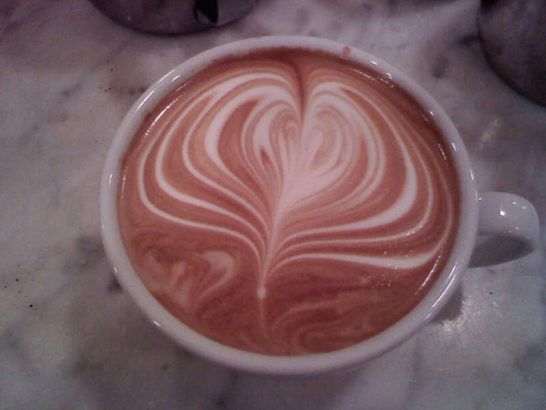 قهوه لته با هنر لته آرت (Latte Art) به شکل قلب سفید