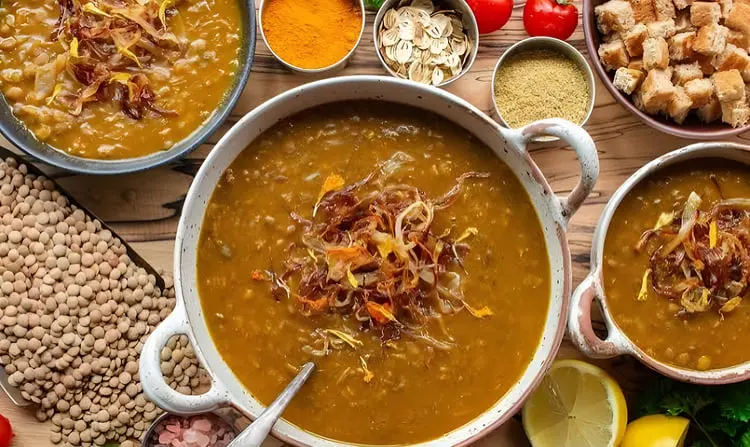 عدسی پخته شده در ظرف سفید همراه با پیاز داغ و ادویه