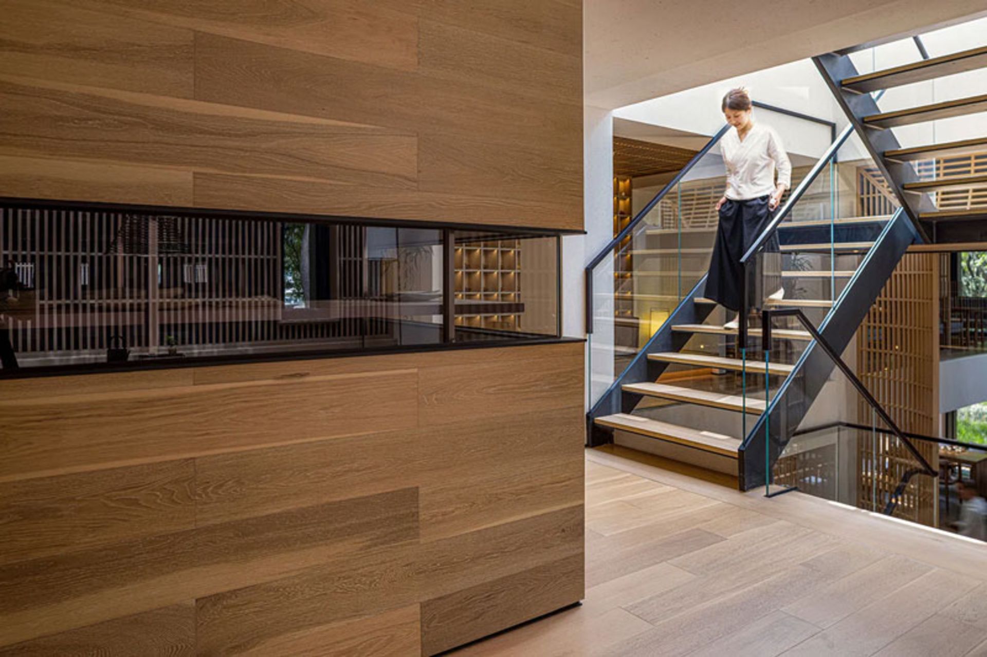 راه‌پله فلزی-چوبی چایخانه دریاچه آبی در کنار دیوار چوبی شیاردار