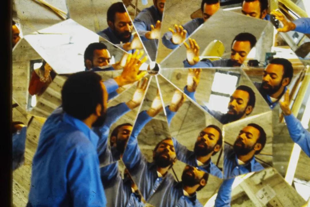 انعکاس چهره و بدن مردی در قطعات مختلف یک آینه چندوجهی