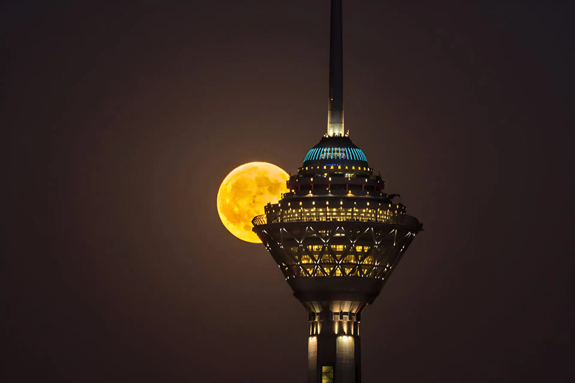 ماه کامل در کنار برج میلاد در آسمان شب تهران