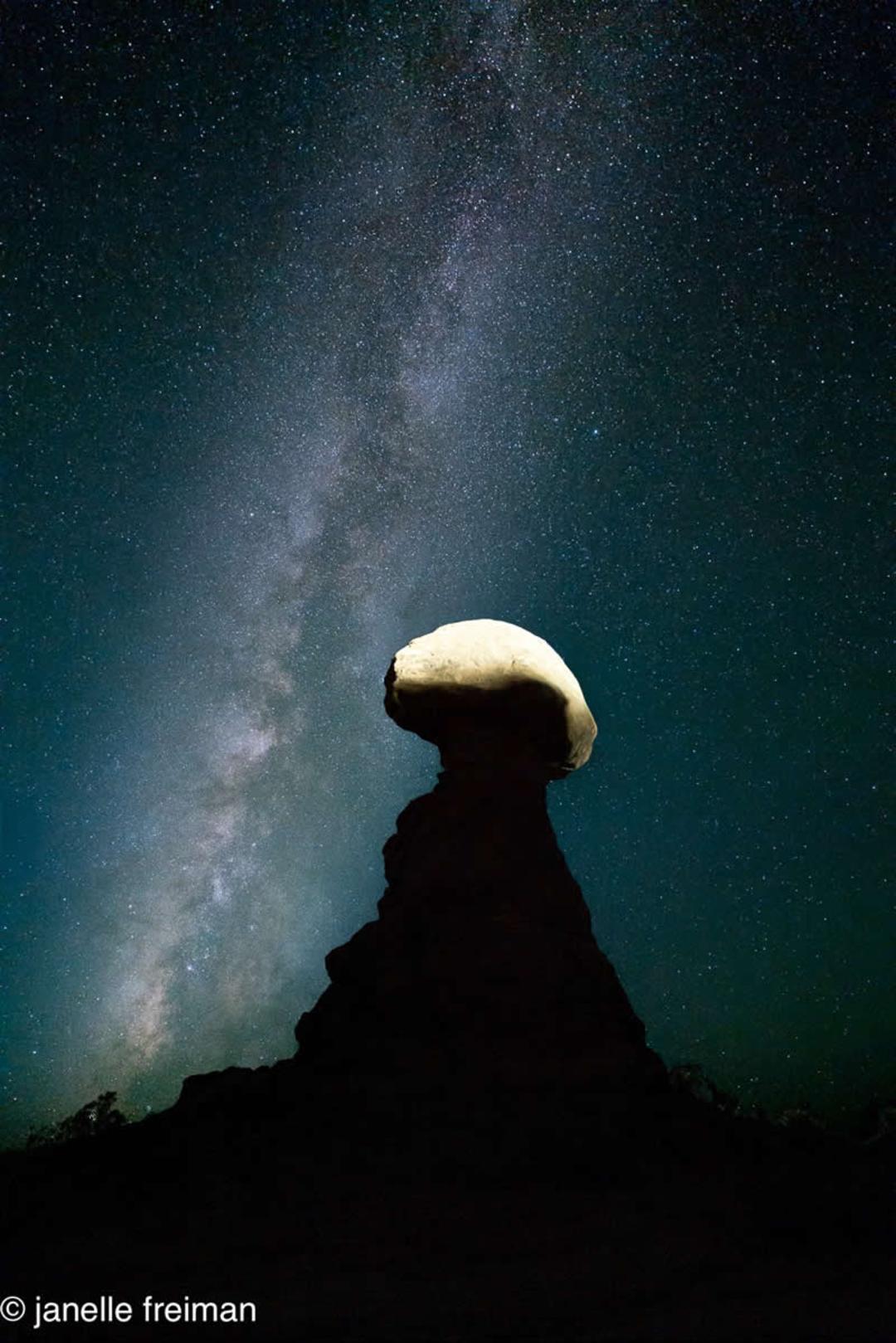 صورت فلکی راه شیری (Milky Way) بالای یک صخره‌ی تک‌ستون در شب