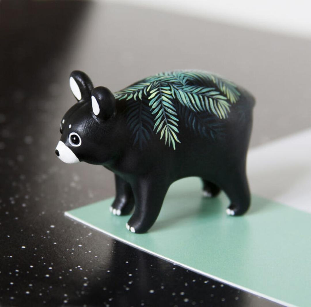 مجسمه مینیاتوری خرس سیاه با نقش‌های برگ سبز روی پشت