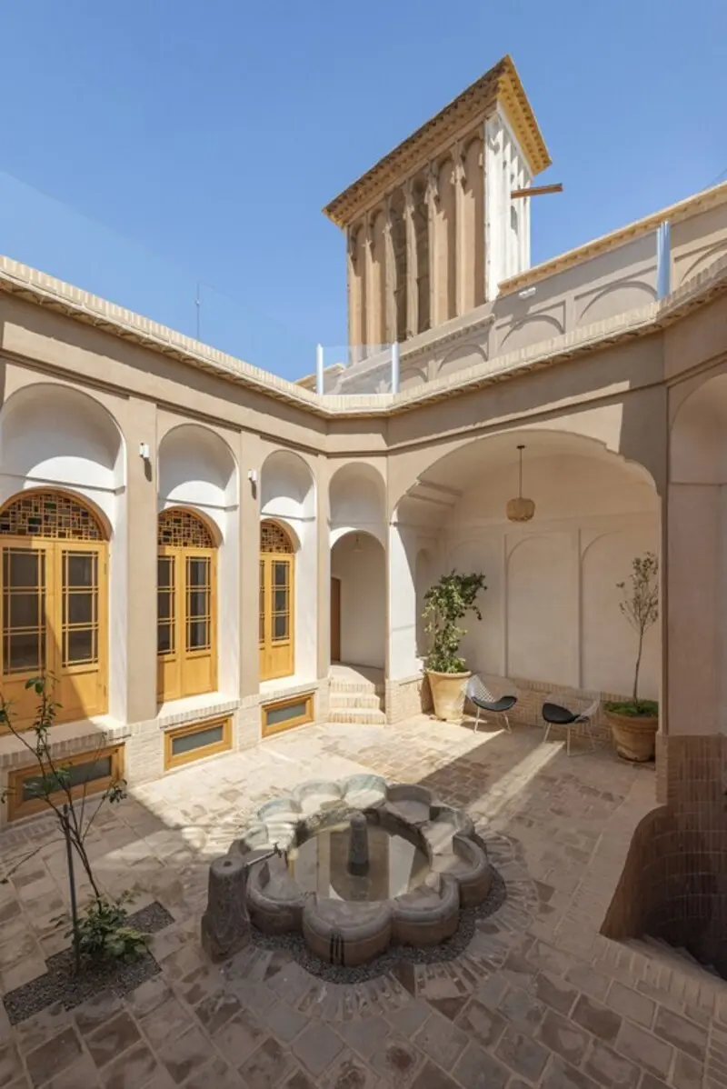 حیاط مرکزی خانه تاریخی مینودر (Minooder) با حوض آب و بادگیر سنتی