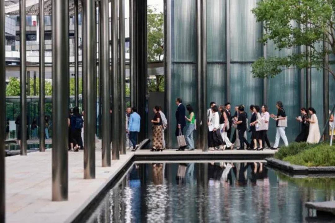 ستون‌های فلزی بلند و حوض آب در محوطه یک ساختمان مدرن