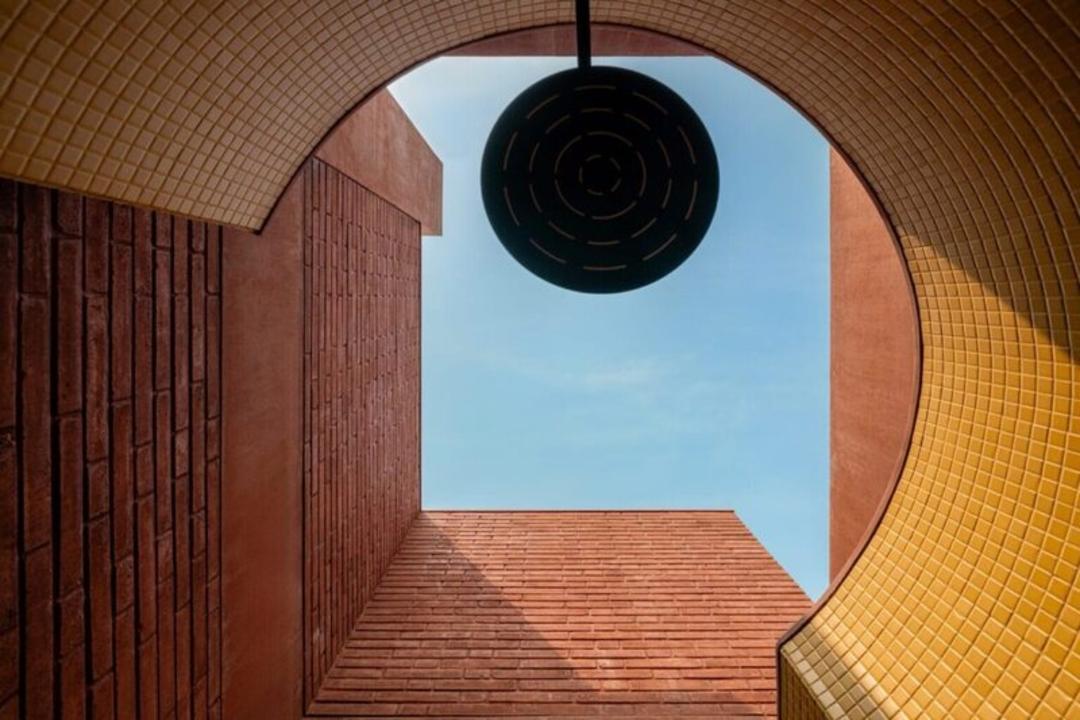 ساختمان مدرن با دیوارهای آجری و بازنمایی هندسی از آسمان آبی