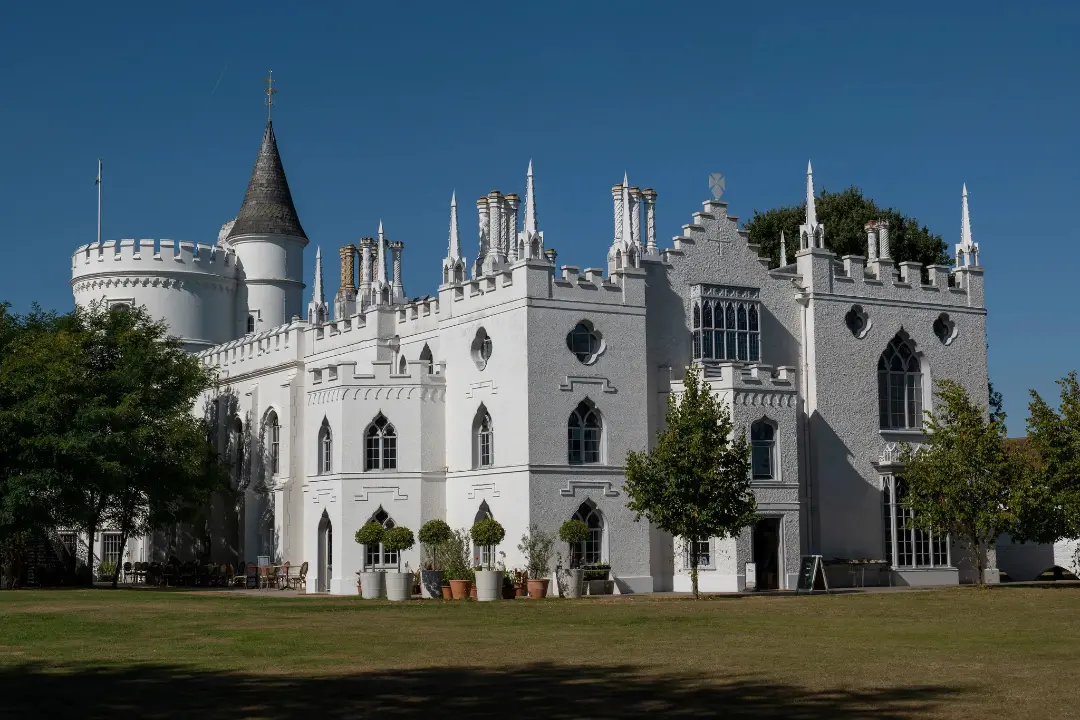عمارت سفید با ویژگی‌های معماری نئوگوتیک (Neo-Gothic) و برج‌های دندانه‌دار