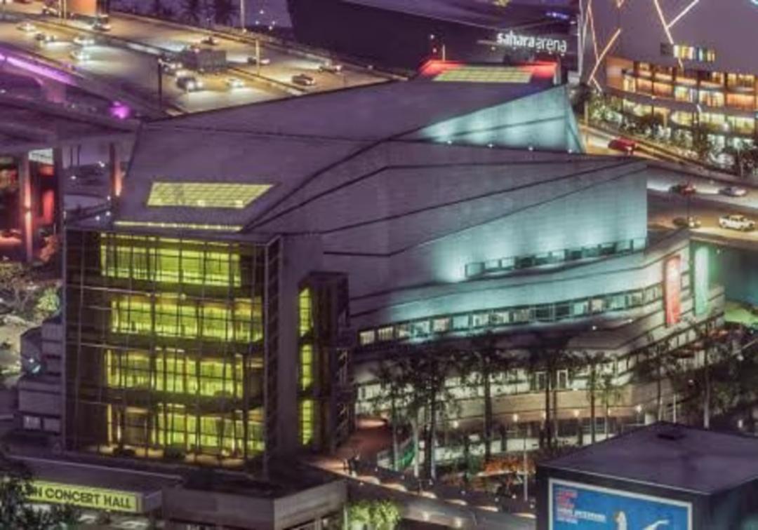 ساختمان مدرن سالن کنسرت (Concert Hall) با نورپردازی زرد در شب