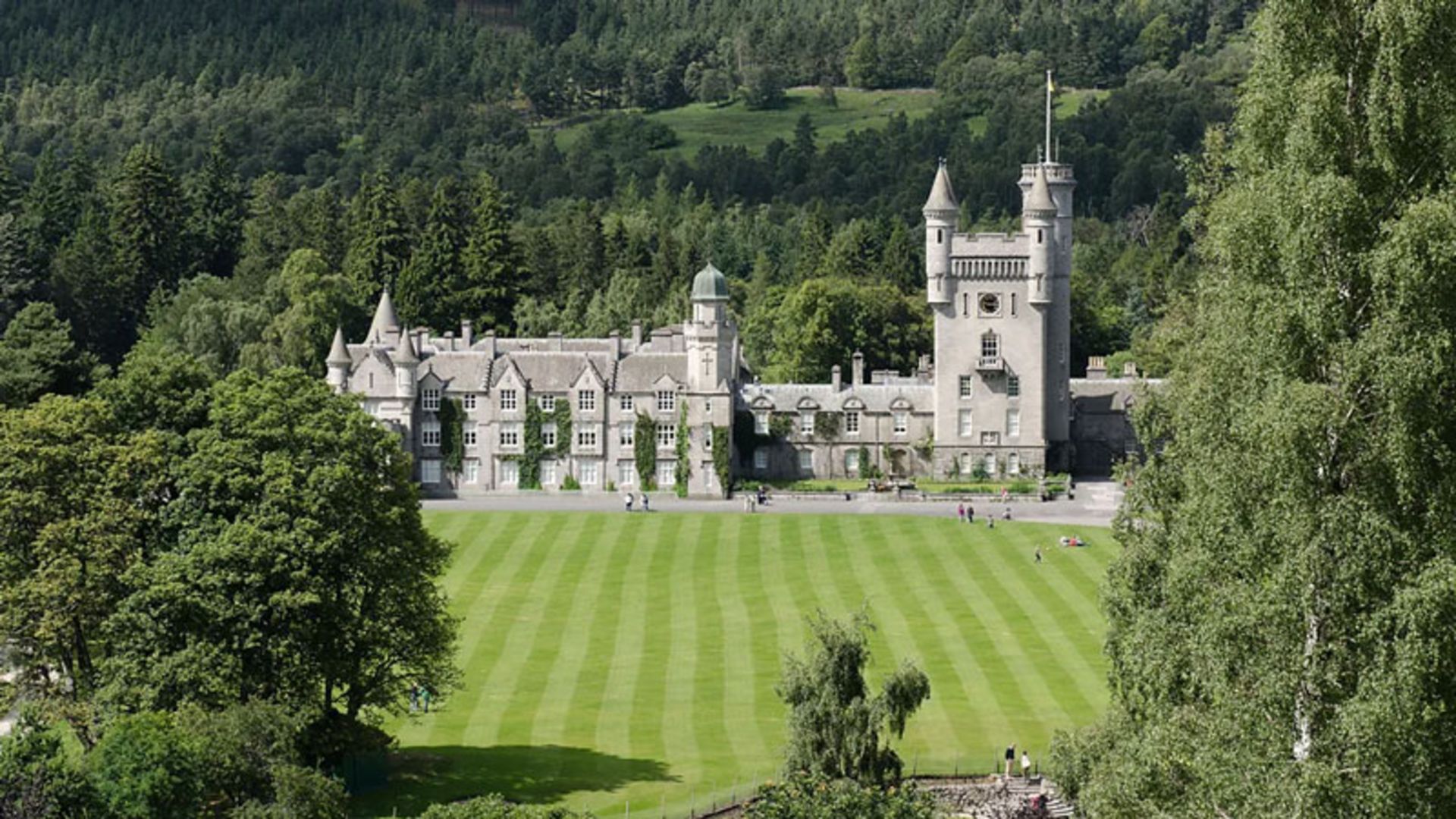 نمای دور کاخ بالمورال با برج‌های سنگی و چمن‌های مرتب