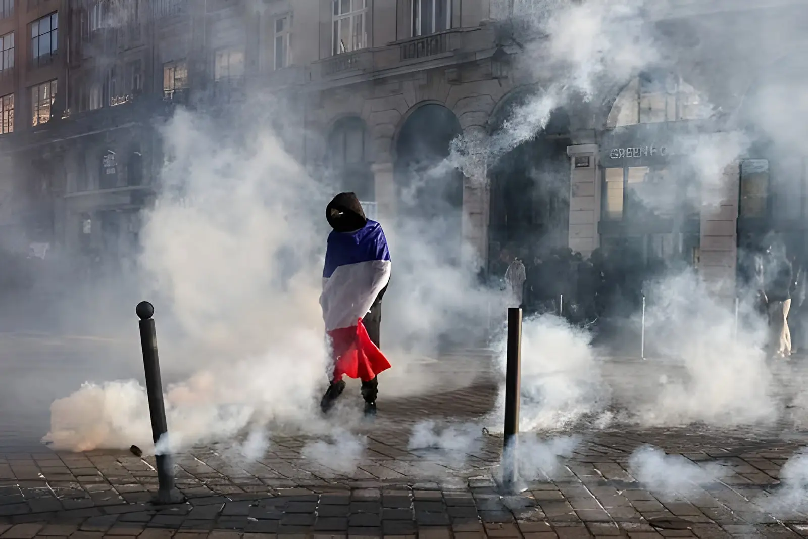 پرچم فرانسه (France) در میان دود حاصل از درگیری‌های خیابانی پاریس