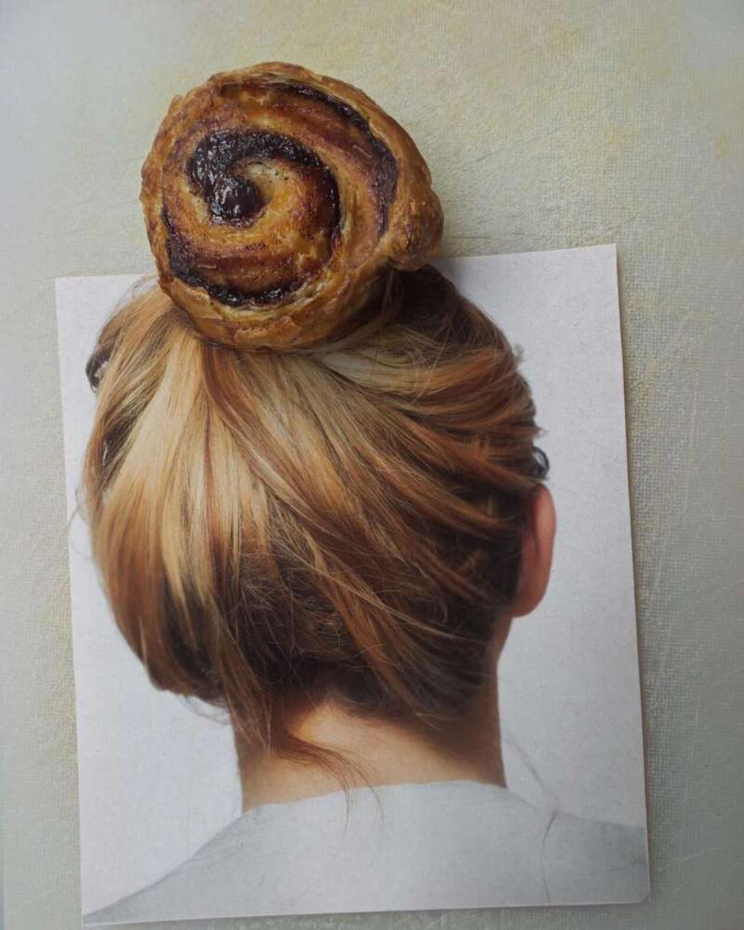نان شیرین لایه‌لایه (Pain au Chocolat) روی بالای موهای جمع‌شده یک زن