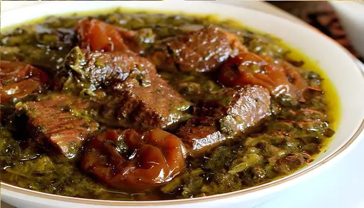 خورش آلو اسفناج شامل تکه‌های گوشت و اسفناج در ظرف سفید