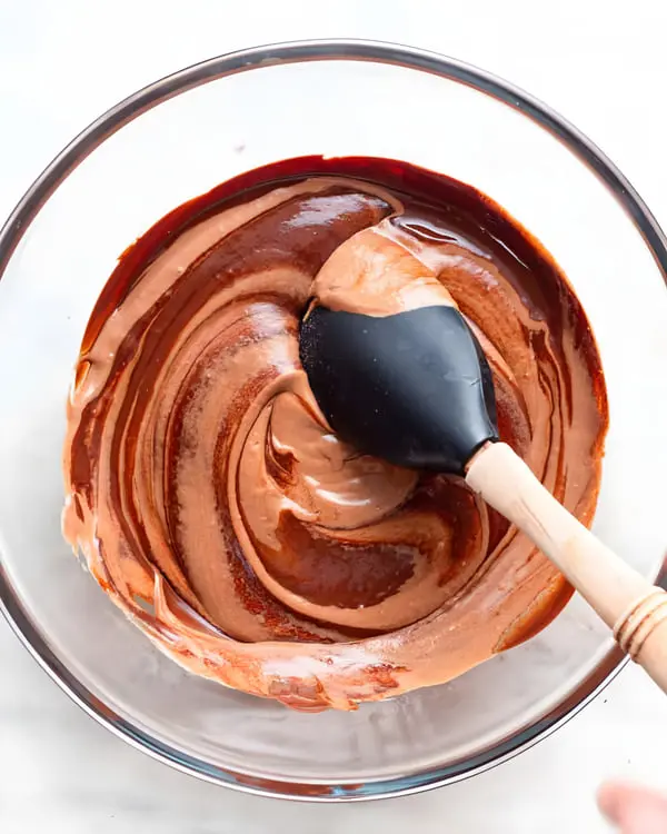 مخلوط کردن پودینگ خرمالو و شکلات در یک ظرف شیشه‌ای با لیسک سیاه
