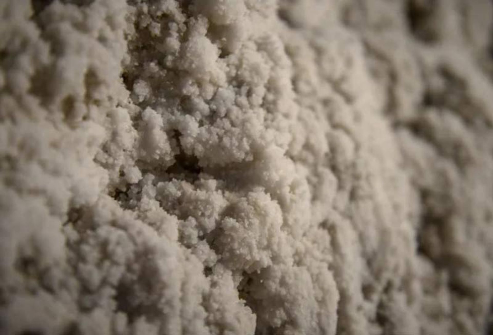 نمای بسیار نزدیک (ماکرو) از بافت بلوری و ناهموار سنگ نمک بر دیواره معدن