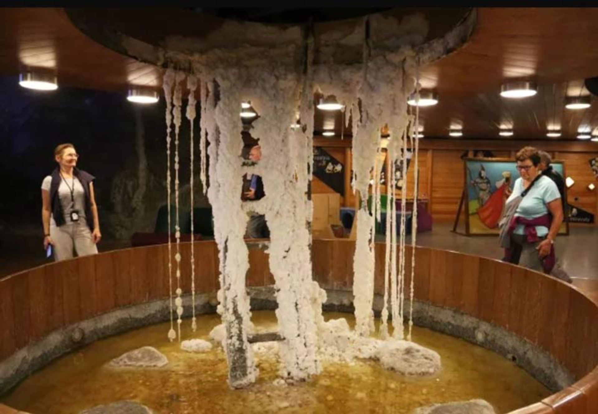 ستون‌های سفید و قندیل‌مانند نمکی در میان یک حوضچه آب شور زیرزمینی