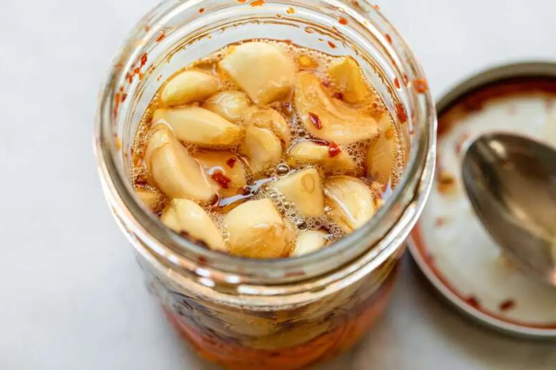 سیر ترشی در روغن و سرکه داخل یک ظرف شیشه‌ای باز