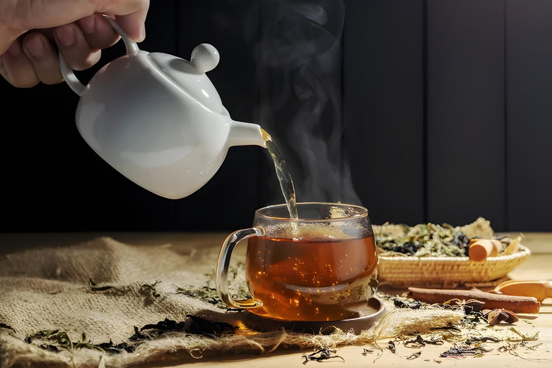 چای در حال ریختن از قوری سفید درون فنجان شیشه‌ای