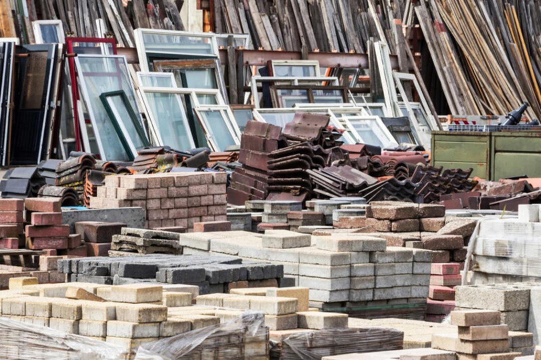 پنجره‌های قدیمی و بلوک‌های سیمانی در انبار مواد ساختمانی بازیافتی